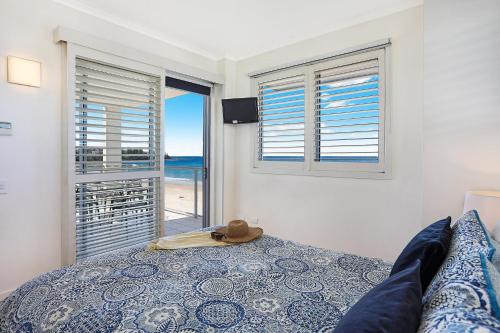 a bedroom with a bed and a view of the ocean at Pandanus Court in Caloundra