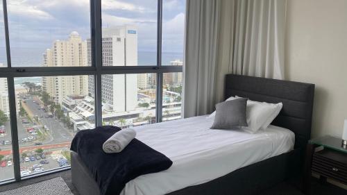 a bedroom with a bed with a view of a city at Solaire Apartments in Gold Coast