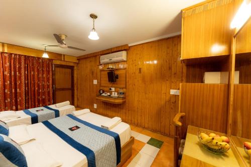 a hotel room with two beds and a table at Hotel Akbar At Dal Lake Ghat Number 1 in Srinagar