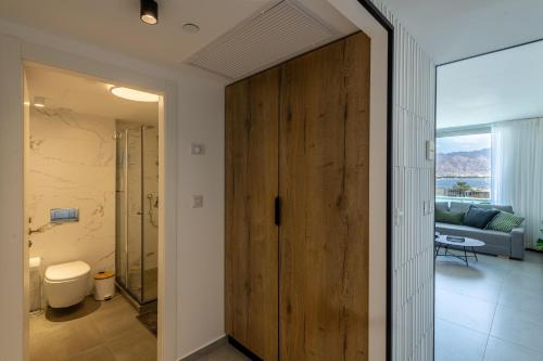 a bathroom with a large wooden door in a room at Seaside Haven-City Center Amazing Pool and Sea view in Eilat