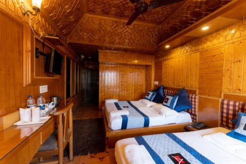 a room with two beds and a desk in a cabin at Hotel Akbar At Dal Lake Ghat Number 1 in Srinagar
