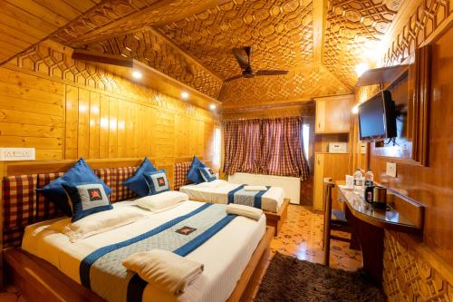 a hotel room with two beds and a television at Hotel Akbar At Dal Lake Ghat Number 1 in Srinagar