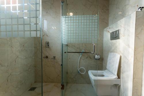 a bathroom with a shower and a toilet at Hotel Akbar At Dal Lake Ghat Number 1 in Srinagar