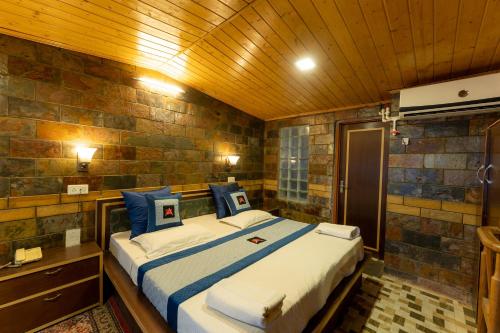 a bedroom with a large bed with blue pillows at Hotel Akbar At Dal Lake Ghat Number 1 in Srinagar