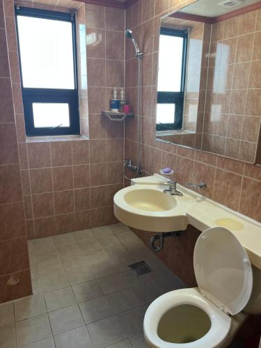 y baño con aseo, lavabo y espejo. en Greenpeace Motel en Gangneung