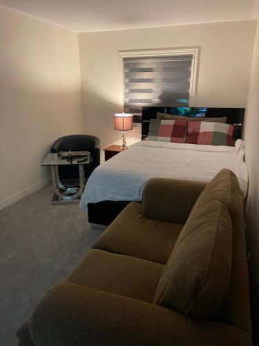 1 dormitorio con 1 cama, 1 sofá y 1 silla en Comfort King, en Oshawa
