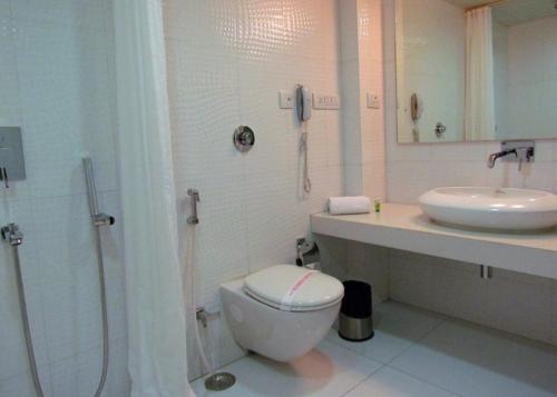 uma casa de banho com um WC, um lavatório e um chuveiro em Cocoon Luxury Business Hotel em Dhanbad