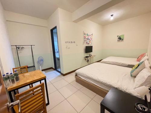 a bedroom with a bed and a table and a desk at 二街窩窩電梯民宿花蓮車站東出口Second street Nest Hostal in Hualien City