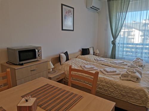 1 dormitorio con 2 camas, mesa y TV en Family Studio Alex⅋Marry en Razlog