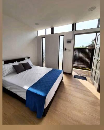 a bedroom with a large bed with a large window at Laman Gadang in Johol