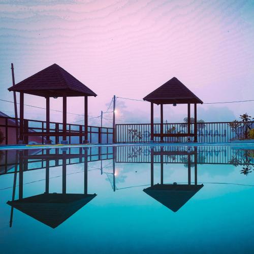 a swimming pool with two gazebos in the water at Laman Gadang in Johol