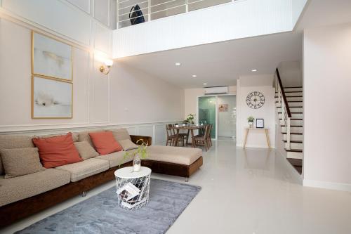 a living room with a couch and a table at Latkrabangbishome Near Suvarnabhumi Airport ลาดกระบังบิซโฮม in Lat Krabang