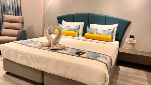 a bedroom with a bed with two swans on it at Hotel The Excellency in Surat