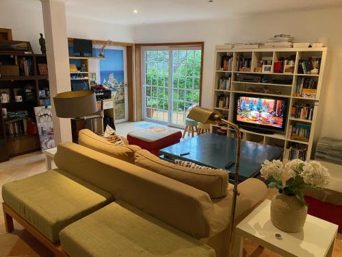 a living room with a couch and a tv at AMAZIGH HOSTEL Rooms & Dorm with Share Kitchen in Cascais