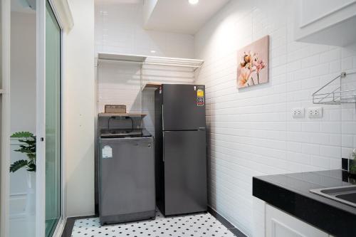 a small kitchen with a refrigerator and a sink at Latkrabangbishome Near Suvarnabhumi Airport ลาดกระบังบิซโฮม in Lat Krabang