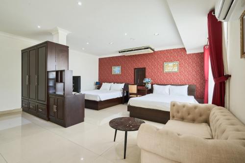 a hotel room with two beds and a couch at Bonita Boutique Hotel in Ho Chi Minh City