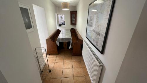 a hallway with a table and a tiled floor at Llanw Malltraeth - Malltraeth Tides in Llangadwaladr