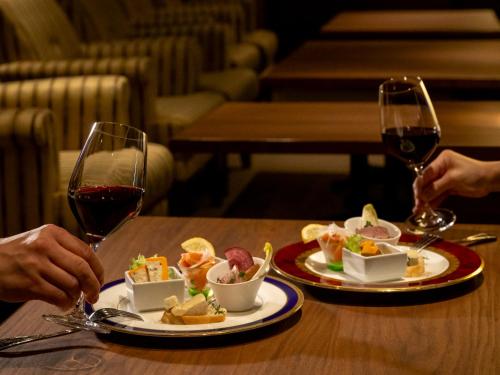 two people sitting at a table with two glasses of wine at ANA Crowne Plaza Akita by IHG in Akita