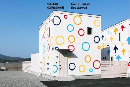 un edificio blanco con una pared con círculos coloridos en 淡路島貸別荘リアンみなと, en Minamiawaji