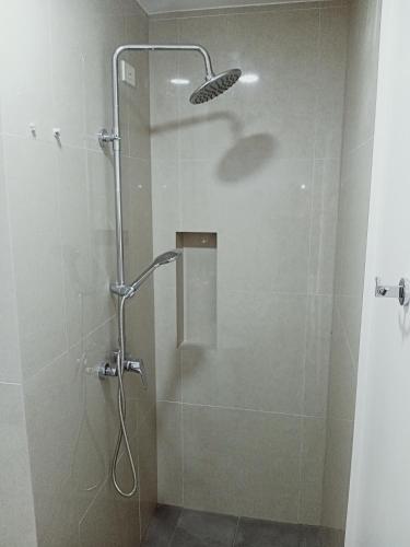 baño con ducha y puerta de cristal en Condotel 810 en Iloílo