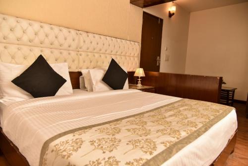 Hotel Lyf Corporate Suites - Near IGI Airport في نيودلهي: غرفة نوم بسرير كبير مع اللوح الأمامي كبير