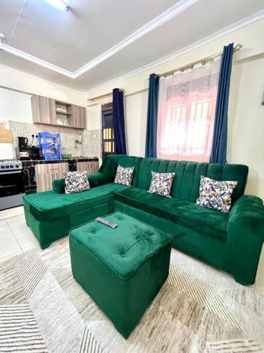 a living room with a green couch in a room at Luxe suite (1bedroom) in Nambale