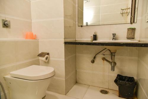 Hotel Lyf Corporate Suites - Near IGI Airport في نيودلهي: حمام مع مرحاض ومغسلة ومرآة