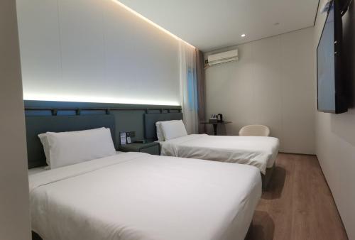 A bed or beds in a room at Shanghai Ange Hotel - Next to Longyang Road Subway Station, Near New Internatonal Expo Center