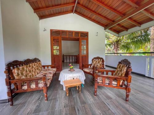 a living room with three chairs and a table at The beach gate villa in Beruwala