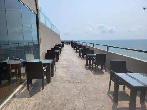 una fila di tavoli e sedie su un balcone con vista sull'oceano di Negombo Bliss on the Beach Luxury Studios by Serendib Vacation a Negombo