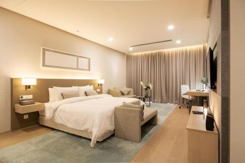 a bedroom with a large white bed and a desk at 188 suites By Seng Home in Kuala Lumpur