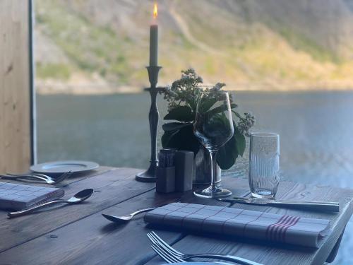 uma mesa de madeira coberta com uma vela e uma vela em Lofoten Cottages em Nussfjord