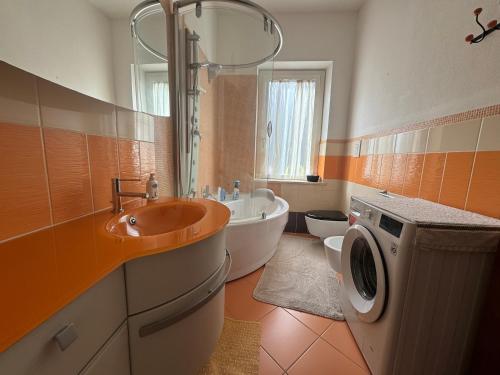 uma casa de banho com uma banheira, um lavatório e uma máquina de lavar roupa em Villa Dei Fiori - casa vacanza em Capoterra
