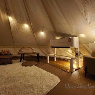 een woonkamer met een tent met een tapijt en een wit tapijt bij Ozone Story-โอโซนสตอรี่ 