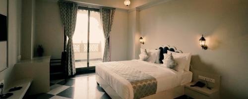 een slaapkamer met een wit bed en een raam bij The Biletha Bagh in Udaipur