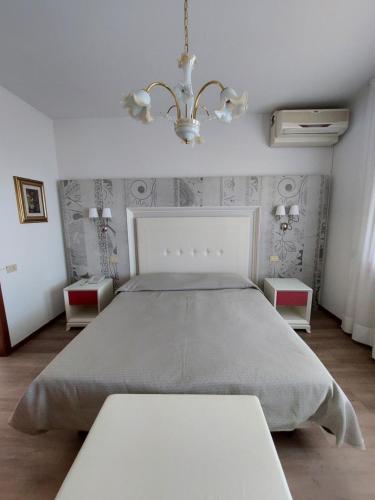 a bedroom with a large bed and two tables at Albergo Alla Pineta in Montebelluna