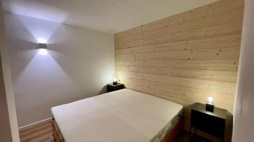 a bedroom with a bed and two lights on the wall at Lys Apartment in Gressoney-la-Trinité