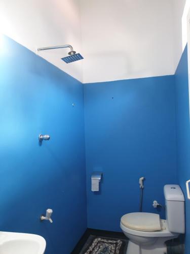 La salle de bains bleue est pourvue de toilettes et d'un lavabo. dans l'établissement Raymond Place -REDSTAR, à Weligama