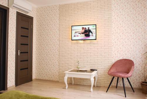 a room with a chair and a table and a picture at Комплекс На Дачі in Vyshpolʼ