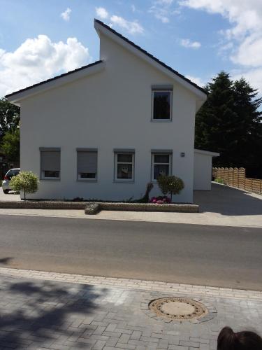 a white house on the side of a street at Gästehaus Ditz in Westoverledingen