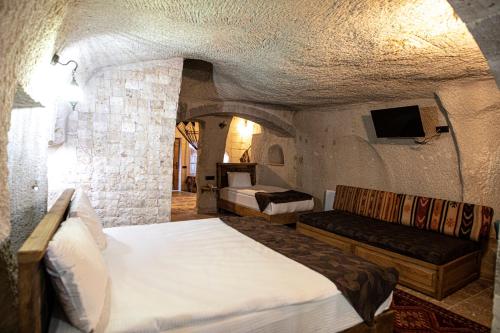 sypialnia z 2 łóżkami i kanapą w pokoju w obiekcie Avilla Cave Hotel w Göreme