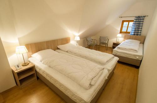a bedroom with two beds and two tables and two lamps at Nova Lake Resort Nová Pec - Lipno in Nová Pec