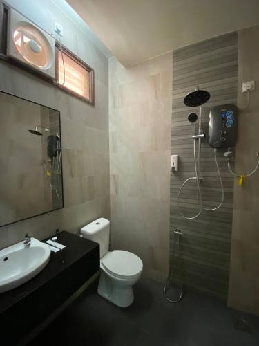a bathroom with a toilet and a sink and a shower at Pandan Laut Beach Resort in Kampung Penarik
