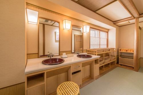 a bathroom with two sinks and a large mirror at Sumiyoshiya in Nagaoka