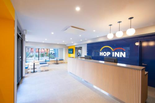 an office lobby with a hop inn sign on the wall at Hop Inn Tokyo Asakusa in Tokyo