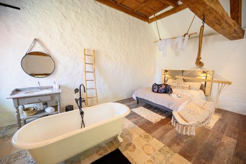 a bathroom with a bath tub and a bed at Maison d'Hôtes Ferme d'Issonges B&B in Marigny-en-Orxois