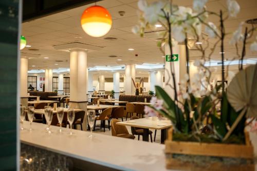 Hotel Marina Resort في بنيدورم: غرفة طعام بها طاولات وكراسي وزهور