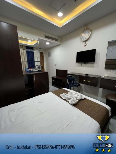 a hotel room with a bed and a flat screen tv at Soulmate Hotel Erbil in Erbil