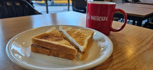 a plate with two slices of bread and a cup of coffee at Ekonomy Hotel Incheon in Incheon