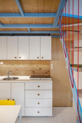 a kitchen with white cabinets and a colorful staircase at Apartment Stone House Krk in Krk